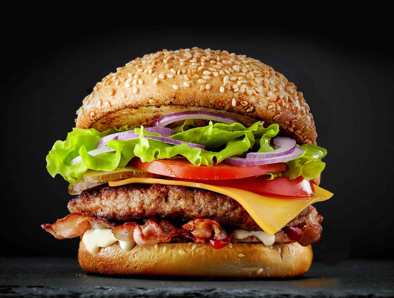 a picture of a burger with a black background